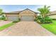 Paver driveway leading to a two-car garage with well-maintained landscaping and a lush lawn at 4416 Amalfi Ave, Sarasota, FL 34243