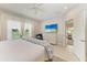 Bright bedroom featuring a TV, white furniture, ceiling fan, and doorway to bathroom at 4416 Amalfi Ave, Sarasota, FL 34243