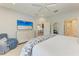 Bright bedroom featuring a TV, white furniture, ceiling fan, and doorway to bathroom at 4416 Amalfi Ave, Sarasota, FL 34243