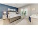 Comfortable bedroom featuring a blue accent wall, decorative pillows, and natural light from the window at 4416 Amalfi Ave, Sarasota, FL 34243