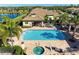 Aerial view of community pool and clubhouse surrounded by lush landscaping and a serene lake at 4416 Amalfi Ave, Sarasota, FL 34243