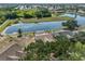 A high angle shot of a property featuring a screened-in pool and adjacent to a scenic pond at 4627 56Th E Dr, Bradenton, FL 34203