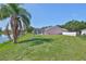 Backyard with screen enclosed pool, lake, and lush green grass at 4627 56Th E Dr, Bradenton, FL 34203
