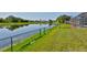 The backyard features a serene pond view, lush green grass, and a secure fenced perimeter at 4627 56Th E Dr, Bradenton, FL 34203