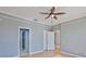 Comfortable bedroom with light gray walls, light wood floors, ceiling fan and access to the bathroom and other rooms at 4627 56Th E Dr, Bradenton, FL 34203
