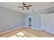 Neutral bedroom featuring wood floors, light gray walls, ceiling fan, crown molding and ensuite bath access at 4627 56Th E Dr, Bradenton, FL 34203