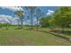 Spacious backyard featuring well-manicured lawn and mature trees under a beautiful blue sky with some clouds at 4812 Greywood Ln, Sarasota, FL 34235
