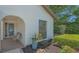 Charming front entry with tiled patio, potted plants, and decorative shrubbery at 4812 Greywood Ln, Sarasota, FL 34235