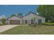 Inviting single-story home featuring a well-manicured lawn, mature trees, and an attached two-car garage at 4812 Greywood Ln, Sarasota, FL 34235