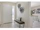 Bright foyer featuring tiled floors, a bench with decorative pillow, and modern metal wall art at 4812 Greywood Ln, Sarasota, FL 34235