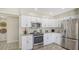 Open kitchen boasts stainless steel appliances, white cabinets, and modern countertops at 4812 Greywood Ln, Sarasota, FL 34235