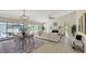 Open-concept living room with a dining area, fireplace, and sliding glass doors to the pool at 4812 Greywood Ln, Sarasota, FL 34235