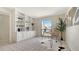 Well-lit office with built-in shelving, a sleek desk, and a large window overlooking the front yard at 4812 Greywood Ln, Sarasota, FL 34235