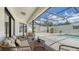 Covered patio with comfortable seating overlooking the pool and landscaped backyard at 4812 Greywood Ln, Sarasota, FL 34235