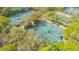 Aerial view of multiple tennis courts surrounded by lush greenery and mature trees at 4812 Greywood Ln, Sarasota, FL 34235