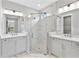 Primary bathroom showcasing a marble tiled shower with frameless glass enclosure and double vanity at 4927 Carova Way, Bradenton, FL 34211