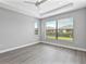 Spacious bedroom with tray ceiling, ceiling fan, and large window overlooking the backyard at 4927 Carova Way, Bradenton, FL 34211