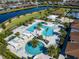 Aerial view of the community pool and cabanas next to a lake in a luxurious community at 4927 Carova Way, Bradenton, FL 34211