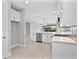Modern, white kitchen with stainless steel appliances and a tile backsplash opens to the living area at 4927 Carova Way, Bradenton, FL 34211