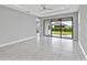 Inviting living room features tile flooring, a ceiling fan, and a sliding glass door to the backyard at 4927 Carova Way, Bradenton, FL 34211