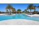 Large pool area with palm trees, lounge chairs, and shallow end volleyball; a perfect outdoor recreation spot at 4927 Carova Way, Bradenton, FL 34211