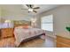Bedroom with hardwood floors, ceiling fan, and a comfortable bed with floral patterned bedding at 5530 21St Street E Ct, Bradenton, FL 34203