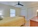 Bedroom featuring wood floors, a ceiling fan, closet, and a bed with yellow bedding at 5530 21St Street E Ct, Bradenton, FL 34203
