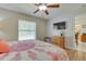 Bright bedroom featuring wood floors, a ceiling fan, and a window, with a TV mounted on the wall at 5530 21St Street E Ct, Bradenton, FL 34203