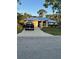 Charming single-story home featuring a metal roof, a long driveway and manicured landscaping at 5530 21St Street E Ct, Bradenton, FL 34203