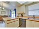Kitchen with wooden counters, stainless steel dishwasher, and adjacent dining area with blue curtains at 5530 21St Street E Ct, Bradenton, FL 34203