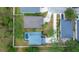 Aerial view of a well-manicured property showcasing the house, driveway, and a backyard pool with enclosure at 5561 Burnt Branch Cir, Sarasota, FL 34232