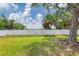 Spacious backyard enclosed by a white fence with lush greenery and mature trees offering a private outdoor space at 5561 Burnt Branch Cir, Sarasota, FL 34232