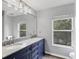 Bathroom featuring a double sink vanity with granite counters and blue cabinets at 5561 Burnt Branch Cir, Sarasota, FL 34232