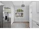 Bright dining area with stainless steel refrigerator, built-in cabinets, and a large window at 5561 Burnt Branch Cir, Sarasota, FL 34232