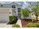 Two-story home with well-manicured landscaping and sidewalk leading to front door at 5561 Burnt Branch Cir, Sarasota, FL 34232