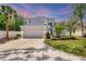 Charming two-story home featuring a manicured front yard, mature trees, and an attached two-car garage at 5561 Burnt Branch Cir, Sarasota, FL 34232