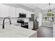 The kitchen features quartz countertops, stainless steel appliances, and white cabinets at 5561 Burnt Branch Cir, Sarasota, FL 34232