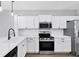 Bright kitchen features white cabinets, stainless steel appliances, and a quartz countertop at 5561 Burnt Branch Cir, Sarasota, FL 34232