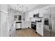 Bright kitchen features white cabinets, stainless steel appliances, and wood-look flooring at 5561 Burnt Branch Cir, Sarasota, FL 34232