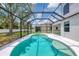 A refreshing kidney-shaped pool with a screened enclosure and sunny backyard creates an inviting outdoor oasis at 5561 Burnt Branch Cir, Sarasota, FL 34232