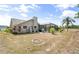 Exterior view of the home's backyard featuring an enclosed pool, fire pit, landscaping and sunny skies at 5750 Carriage Dr, Sarasota, FL 34243