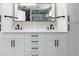 Contemporary bathroom with double sinks, quartz counters and black hardware at 5750 Carriage Dr, Sarasota, FL 34243