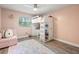 Bright bedroom features a white loft bed, desk and storage, plus a colorful rug and pink walls at 5750 Carriage Dr, Sarasota, FL 34243