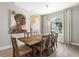 Dining room with wood table, chairs, hardwood floors, a large painting and modern hanging lamps at 5750 Carriage Dr, Sarasota, FL 34243