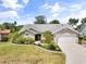 Beautiful single Gathering home featuring a well-manicured lawn, mature landscaping and an attached two-car garage at 5750 Carriage Dr, Sarasota, FL 34243