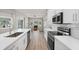 Open kitchen boasts stainless appliances, white cabinets and countertops, connecting to living areas with natural light at 5750 Carriage Dr, Sarasota, FL 34243