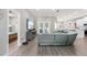 Open-concept living room with gray couch, hardwood floors, and french doors to the back yard at 5750 Carriage Dr, Sarasota, FL 34243