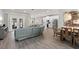 Open-concept living room featuring gray couch, hardwood floors, kitchen and dining table at 5750 Carriage Dr, Sarasota, FL 34243
