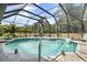 Sparkling pool is surrounded by a screened enclosure, landscaping, and plenty of lounge space at 5750 Carriage Dr, Sarasota, FL 34243