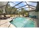 Screened-in pool area with outdoor seating and a lush landscape at 5750 Carriage Dr, Sarasota, FL 34243